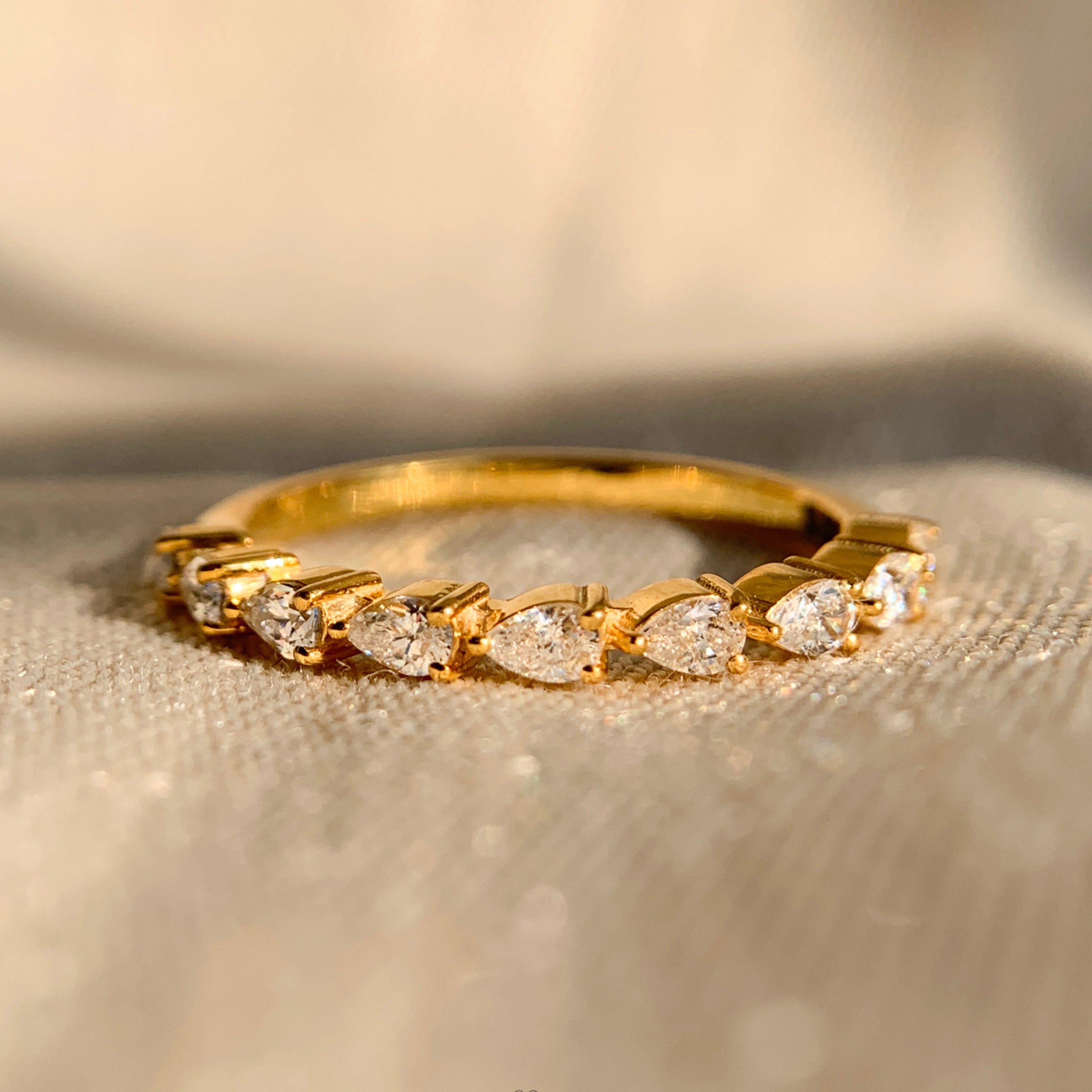 Lab created pear shaped diamond gold band with sleek minimalist design